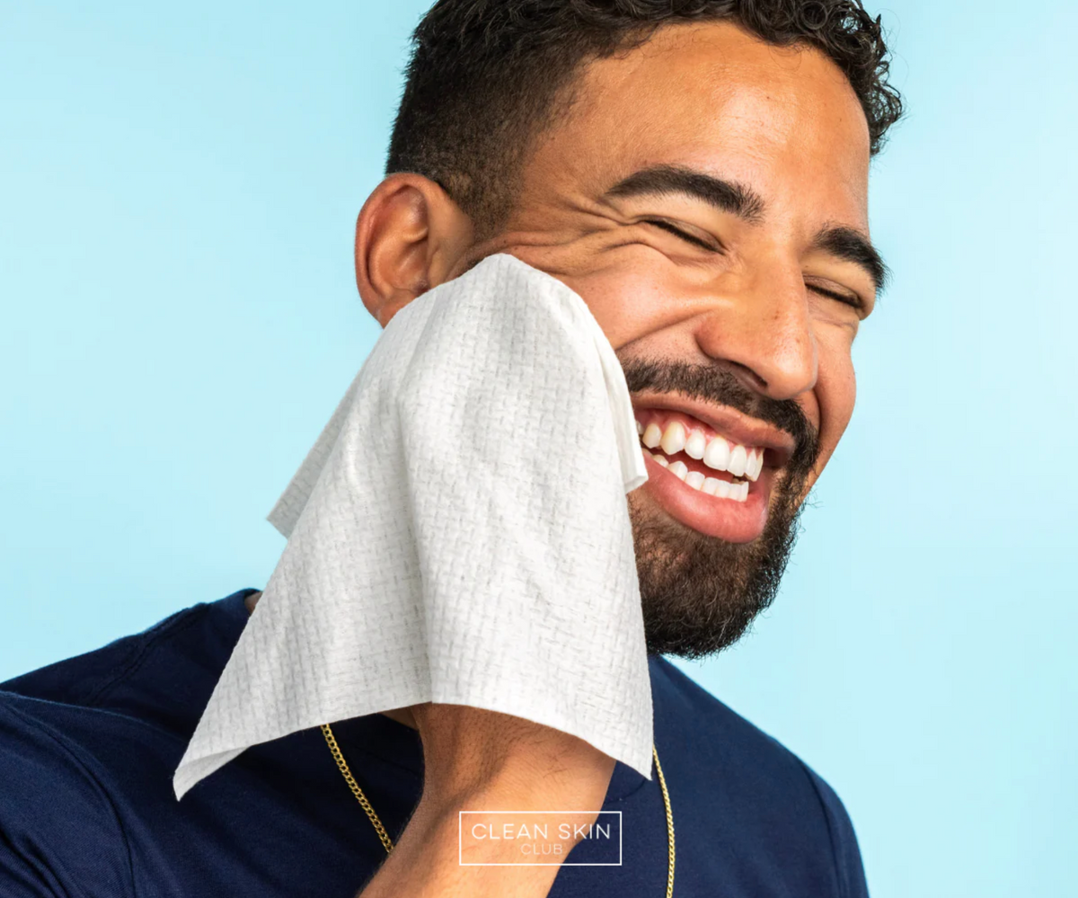 a man using a clean skin club towel on his face
