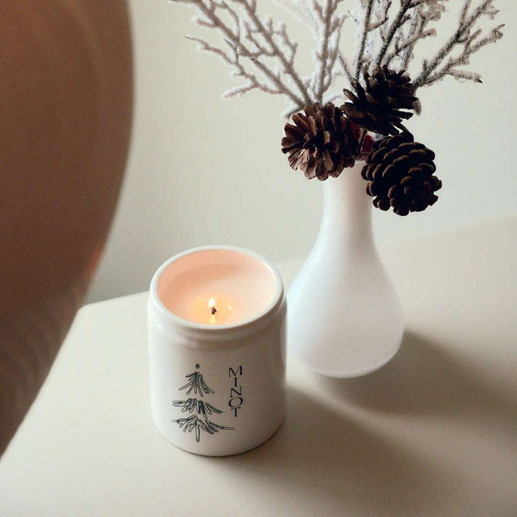 Under The Tree Candle with pine, fir, cedarwood, and clove scents in a 7 oz soy wax jar with gold lid
