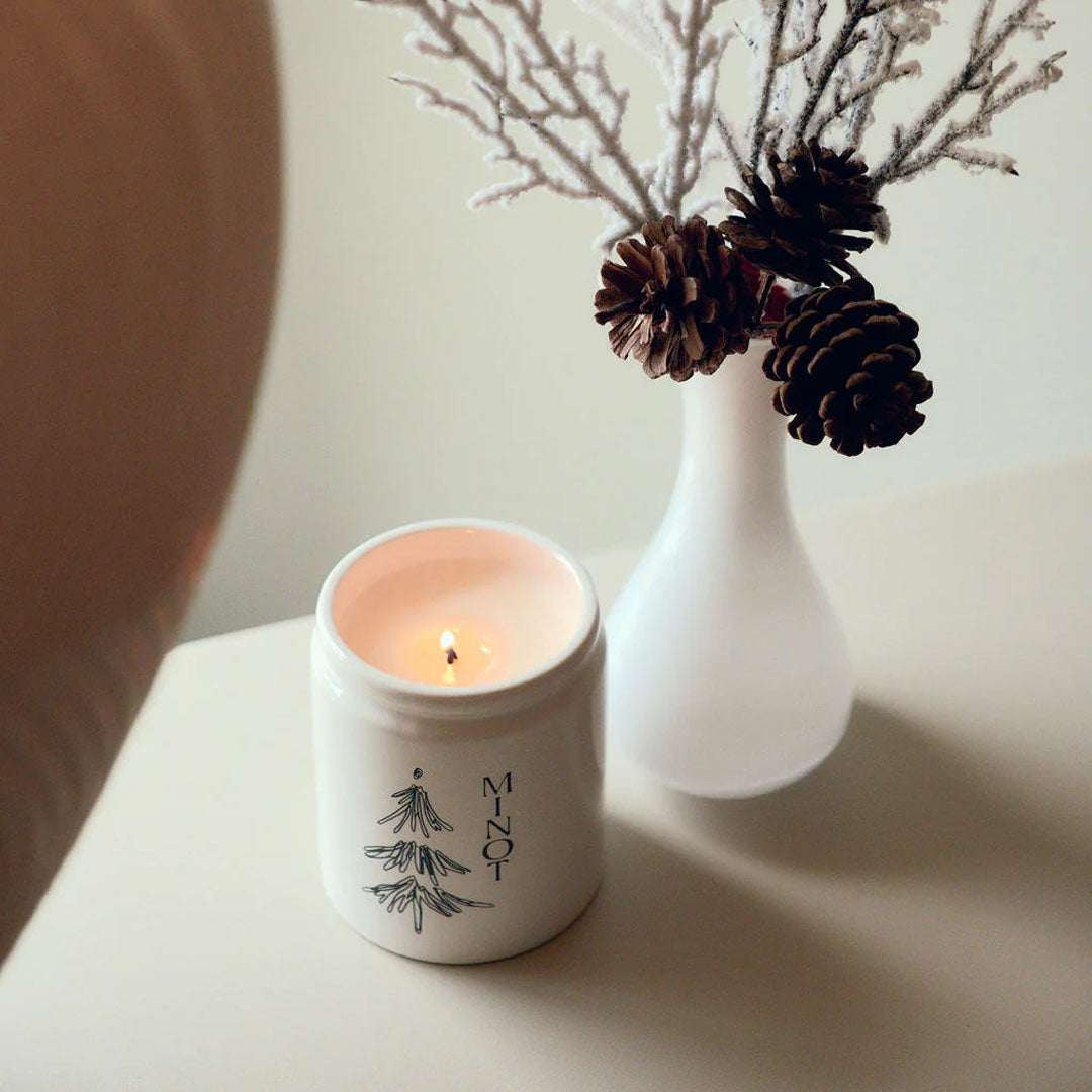 Under The Tree Candle with pine, fir, cedarwood, and clove scents in a 7 oz soy wax jar with gold lid